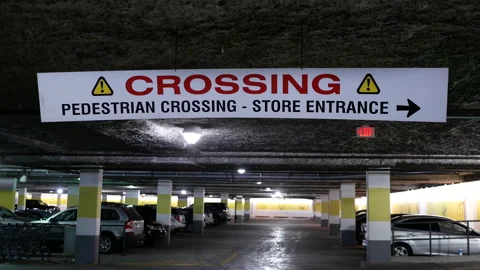 Motion of pedestrian crossing and store entrance sign hanging on roof Stock Footage 89736889