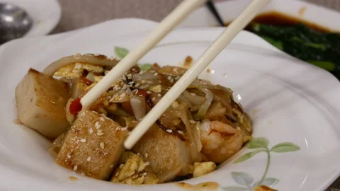 Motion of people eating pan fried turnip cake dim sum Stock Footage 102588089