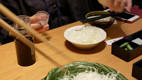 Motion of people eating of shred cabbage on table inside Japanese restaurant Stock Footage 99263633