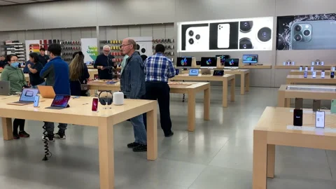 Motion of people playing a new iPhone inside the Apple store with 4k resolution. Video stock 117813309
