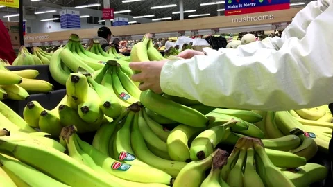 Motion of people selecting banana inside superstore produce department Stock Footage 70975086
