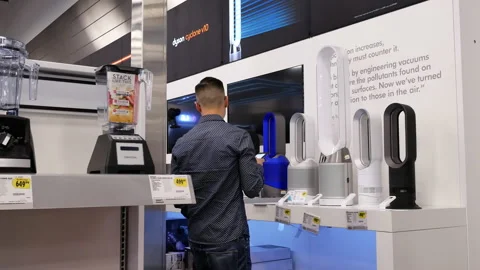 Motion of people shopping dyson tower fan inside electronic store Stock Footage 89679034