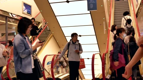 Motion of people taking escalator inside shopping mall in Taiwan Stock Footage 98279170