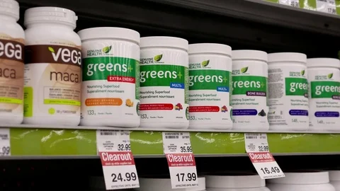 Motion of people taking greens multi plus inside Shoppers drug mart store Stock Footage 74475202