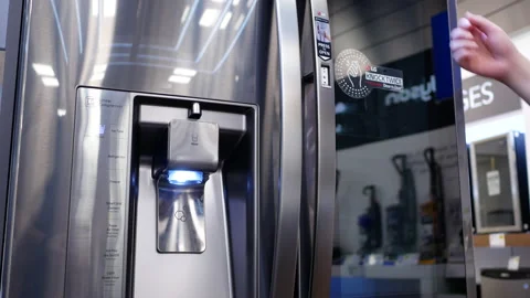 Motion of people trying a new fridge inside electronic store Stock Footage 89679393