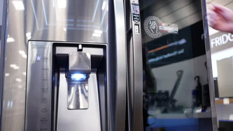 Motion of people trying a new fridge inside electronic store Stock Footage 89700904