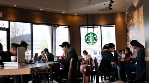 Motion of people using laptop to do homework inside Starbucks store Stock Footage 83767463