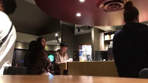 Motion of people waiting for their drink inside Starbucks store Stock Footage 79636143