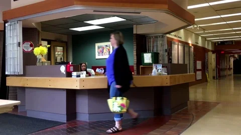 Motion of people walking through guest services counter Video stock 71700492