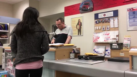 Motion of person mailing parcel at post office inside shopper drug mart Stock Footage 123043247