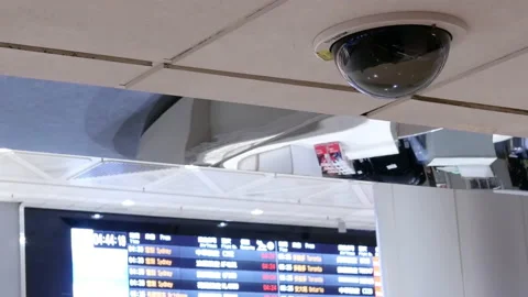 Motion of security camera in front of flight schedules board inside airport Video stock 98570344