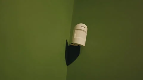 Motion sensor detecting movement on a green wall Stock Footage 343550487