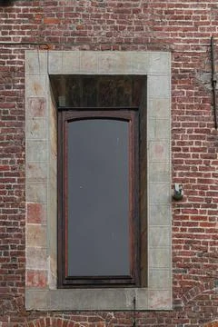 Motion sensor instead of a metal grille near a large vintage window on an old Stock Photos