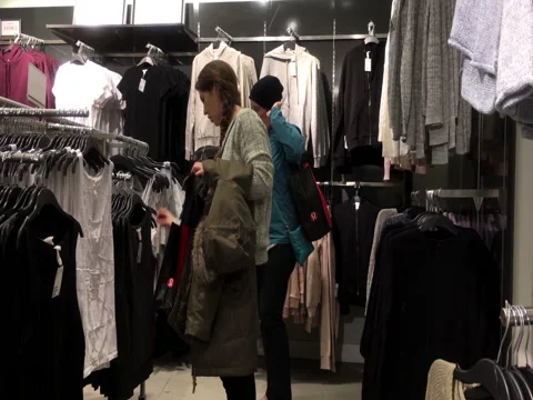Motion of shopper buying clothes and comparing with another one Stock Footage 84806794