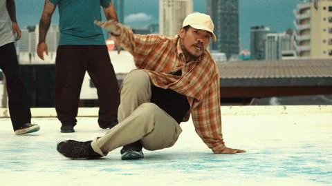 Motion shot of skilled hipster doing break dance at sky scrapper. Endeavor. 库存照片