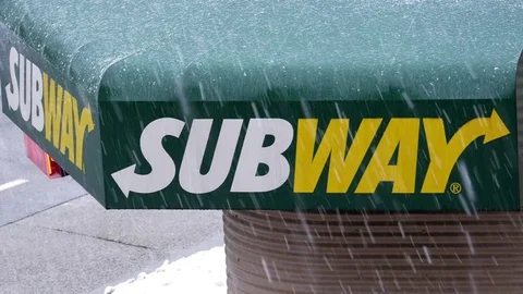 Motion of subway store sign with traffic flow on cold blizzard snow winter day Stockbeeldmateriaal 73342907
