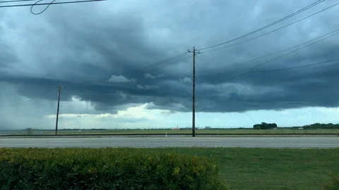 Motion time-lapse of a dark thunderstorm as traffic drives down a busy highway 스톡 동영상 93567231