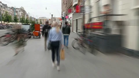 Motion time lapse, walk along Damrak avenue sidewalk, many people around Stock Footage 130536674