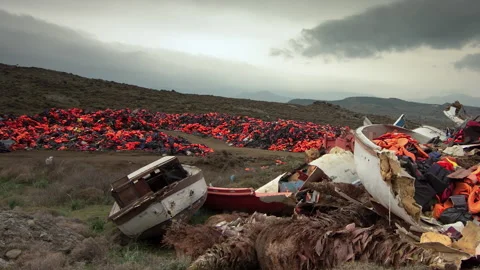 MOTION TIMELAPSE PAN across wrecked refugee boats and lifejackets, Lesbos, 動画素材 145899672
