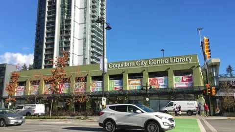 Motion of traffic flow and Coquitlam city centre library building on road Stock Footage 98560320