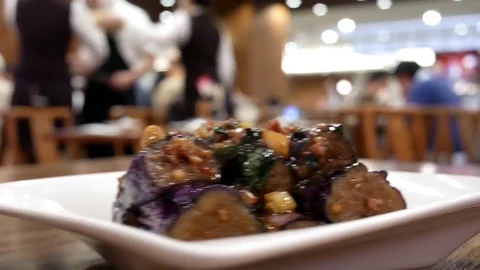 Motion of waiter serving fried eggplant on table for customer inside restaurant Video stock 82955525