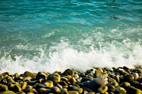 Motion of wave splashed on Rounded rocks on beach, motion blur Stock-Fotos