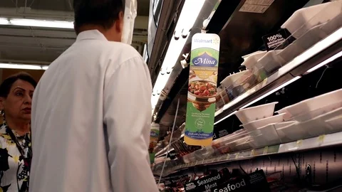 Motion of woman asking worker about meat product inside Walmart store Stock Footage 75026495