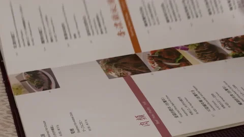 Motion of woman looking at menu inside Chinese restaurant Stock Footage 100966849