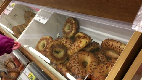 Motion of woman selecting bagel on bulk food section inside superstore Stock Footage 91375127