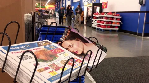 Motion of woman taking flyer inside Walmart store with 4k resolution Stock Footage 68361954