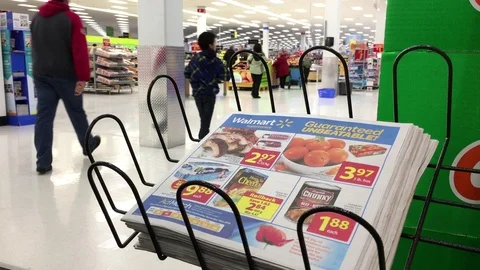 Motion of woman taking flyer inside Walmart store with 4k resolution Stock Footage 69841965