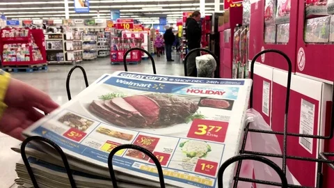 Motion of woman taking flyer inside Walmart store with 4k resolution Stock Footage 71023407