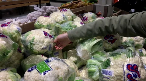 Motion of woman's hand picking cauliflower inside superstore Stock Footage 68594012