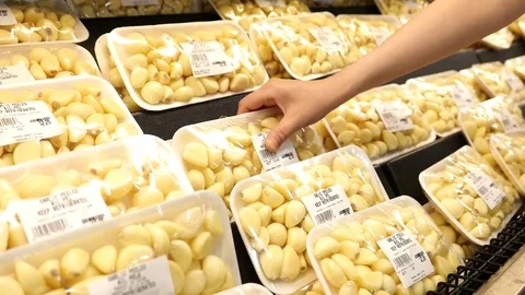 Motion of woman's hand picking garlic inside superstore with 4k resolution Video stock 80006960