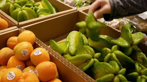 Motion of woman's hand picking starfruit inside Superstore with 4k resolution Stock Footage 90018879