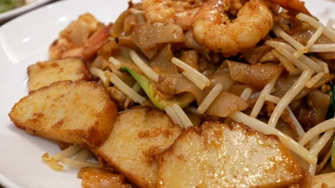 Motion of work fried flat noodles on table inside restaurant with 4k resolution. Video stock 90278526