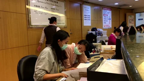 Motion of worker checking receipt at medical reception area inside hospital Stock Footage 86494683