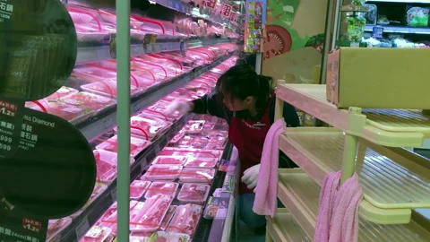Motion of worker cleaning display fresh meat product shelf Stock Footage 100097734