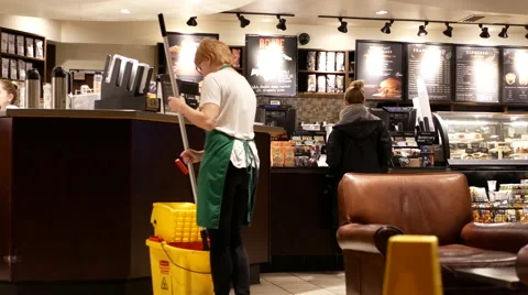 Motion of worker cleaning floor inside Starbucks store Stock Footage 69006189