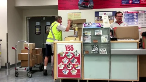 Motion of worker collecting parcel at post office inside shopper drug mart store Stock Footage 77170411
