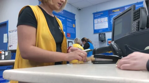 Motion of worker counting money at customer service counter inside Walmart Stock Footage 93531640