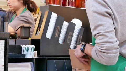 Motion of worker filling sugar on table inside Starbucks store Video stock 105450610