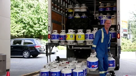 Motion of worker moving propane tank on display rack for sale Stock Footage 78043260