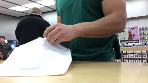 Motion of worker packing gamepad for customer inside Apple store Stock Footage 94425059