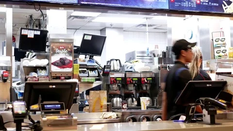 Motion of worker preparing coffee for customer at mcdonalds check out counter Stock Footage 73104514