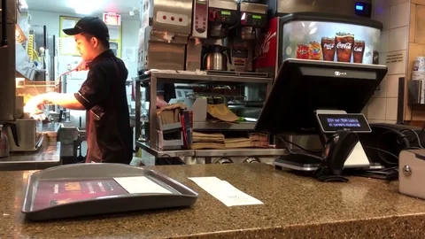 Motion of worker preparing food for customer at Mcdonalds check out counter Stock Footage 85377712