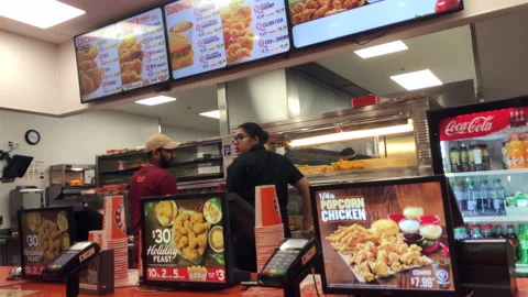 Motion of worker preparing food for customer inside Popeyes chicken Stock Footage 121089817