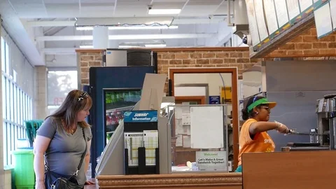 Motion of worker preparing sandwich for customer inside subway store 動画素材 80327662