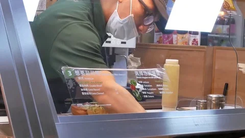 Motion of worker preparing sandwich for customer inside subway store 動画素材 84077688