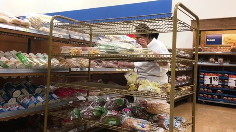 Motion of worker stocking bread at display rack inside superstore Stock Footage 100737322